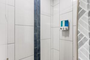 a shower with a blue and white tile wall at Oklahoma Oasis House in Del City