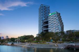 Un edificio alto vicino a un corpo d'acqua di Holiday Inn Quanzhou Donghai, an IHG Hotel a Quanzhou