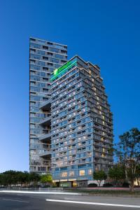 un grand bâtiment avec un panneau vert dans l'établissement Holiday Inn Quanzhou Donghai, an IHG Hotel, à Quanzhou