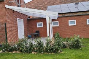 Un auvent sur le côté d'une maison en briques dans l'établissement Ferienwohnung Wildgans 2 Dollart Ostfriesland, à Bunde