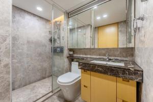 y baño con aseo y ducha acristalada. en Yidu-Doya Apartment, en Guangzhou