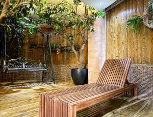 a wooden bench sitting in a room with a tree at All-Ur Boutique Motel -Chia Yi Branch in Chiayi City