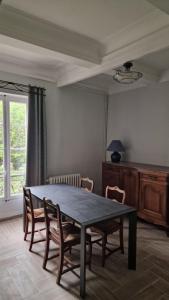 een eetkamer met een tafel en stoelen en een raam bij bastide St Joseph in Eyguières