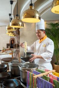 a chef preparing food in a restaurant kitchen at Radegast Hotel CBD Beijing in Beijing
