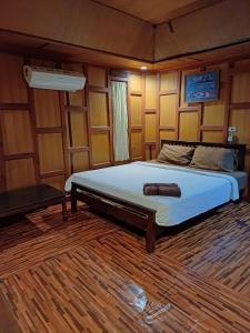 a bedroom with a bed in a room with wooden walls at Orchid Home in Koh Tao