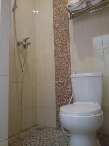 La salle de bains est pourvue d'une douche et de toilettes. dans l'établissement Roemah kita hotel, à Ngaglik