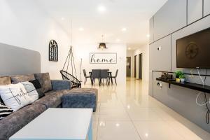 a living room with a couch and a dining room at Manhattan Condominium Ipoh in Ipoh