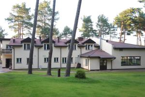 a large white house with trees in the yard at Blue Resort Ostrowo in Ostrowo