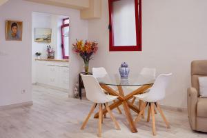 a dining room with a glass table and white chairs at Apartamento Loft en el centro de Peralada in Peralada +11 photos