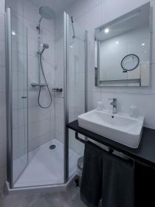 a white bathroom with a sink and a shower at Gandersheimer Boardinghouse in Bad Gandersheim