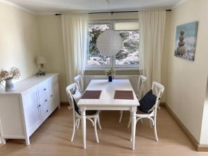 a white dining room with a white table and chairs at NEU! Moderne Fewo Schieke in Schleiz