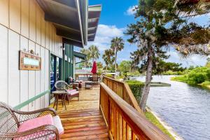 a wooden deck with benches and tables and water at Riverside Serenity - Unit A in Bradenton