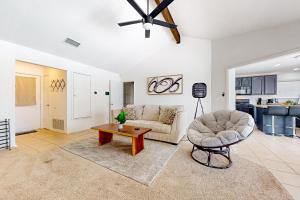 uma sala de estar com um sofá, uma cadeira e uma mesa em Peachtree em Round Rock