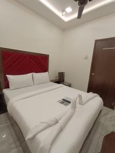 a large white bed with a red headboard in a room at AR Residency in Mumbai