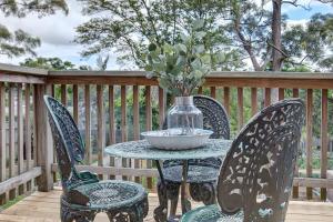 uma mesa e cadeiras com um vaso no deque em Cute Heritage Home with Balcony close to the City em Sydney