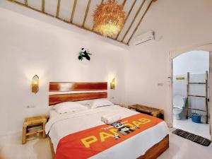 um quarto com uma cama grande num quarto em Panda Home em Gili Trawangan