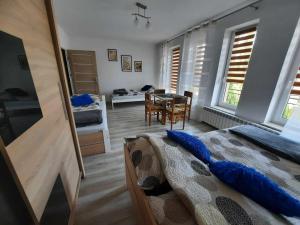 a bedroom with a bed and a dining room at Noclegi Janina Surmacz in Zwierzyniec
