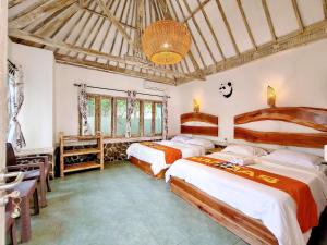 a bedroom with two beds in a room at Panda Home in Gili Trawangan