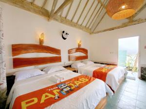 a room with three beds in a room at Panda Home in Gili Trawangan