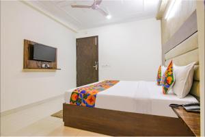 - une chambre avec un lit et une télévision murale dans l'établissement Del Fox Hotel Shanti Residency At New Delhi Railway Station, à New Delhi