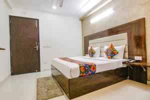 a bedroom with a large bed with a wooden headboard at Del Fox Hotel Shanti Residency At New Delhi Railway Station in New Delhi