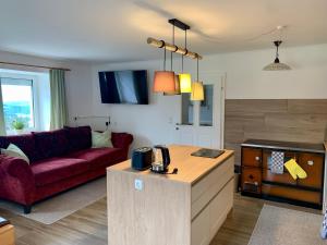 a living room with a red couch and a kitchen at Ferienhaus Frieda 