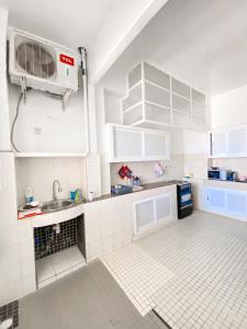a white kitchen with a sink and a microwave at Ideal F3 in Dakar