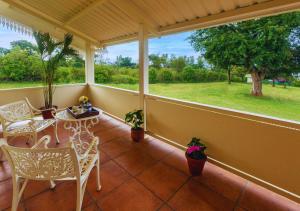 un porche cubierto con sillas y mesa en Wild Pastures by Nature Stays, en Masinagudi