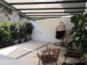 a patio with chairs and a table and a swing at Gaia Apartment II in Parga +2 photos