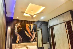 - une chambre dotée d'un ventilateur de plafond et d'une peinture murale dans l'établissement Bhoomika Royal Villa, Kolhapur, à Kolhapur
