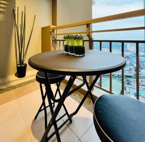 uma mesa com vasos de plantas numa varanda em Modern Contemporary 1BR Fully Furnished Condo with Balcony at Prisma Residences em Manila