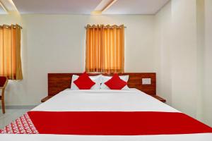 - une chambre dotée d'un lit rouge et blanc avec des oreillers rouges dans l'établissement Super OYO Hotel Silver House Near Mantri Square Mall, à Bangalore
