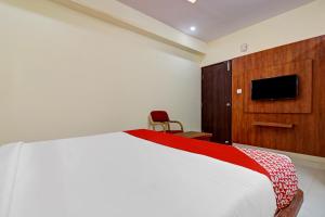 - une chambre avec un lit, une armoire et une télévision dans l'établissement Super OYO Hotel Silver House Near Mantri Square Mall, à Bangalore