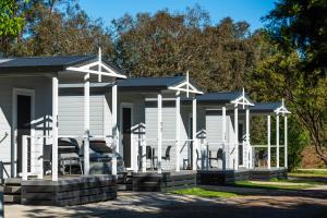 a white modular house with a porch at Gulgong Tourist Park in Gulgong