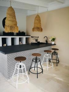 a kitchen with a black counter and some stools at Pensiunea Coralia in Deva