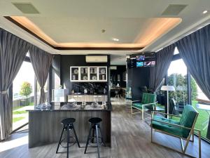um salão com cadeiras verdes e um bar num quarto em Azumi Boutique Hotel em Manilla