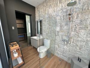 a bathroom with a shower and a toilet and a sink at Azumi Boutique Hotel in Manila