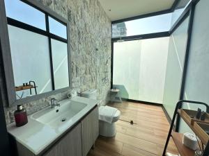 ein Bad mit einem Waschbecken, einem WC und einem Fenster in der Unterkunft Azumi Boutique Hotel in Manila