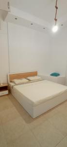 Una cama blanca en una habitación con una cruz en la pared en Karnayo Bay apartment, en Kavala