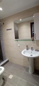 y baño con lavabo, aseo y espejo. en Karnayo Bay apartment, en Kavala