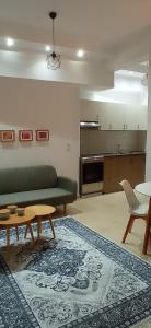 sala de estar con sofá, mesa y alfombra en Karnayo Bay apartment, en Kavala