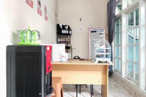 a room with a desk and a computer on a table at RedDoorz Syariah near Transmart Jambi in Paalmerah