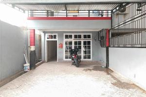 a motorcycle parked inside of a garage at RedDoorz Syariah near Transmart Jambi in Paalmerah