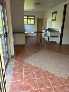 an empty room with a table and a tiled floor at Farnborough Stay in Yeppoon
