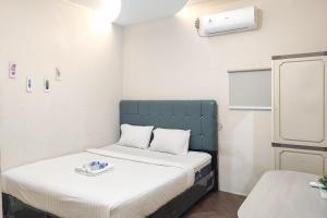 Habitación pequeña con 2 camas. en RedDoorz Syariah near Transmart Jambi, en Palmerah