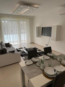 una sala de estar con una mesa con platos. en Luxury Cordia Apartment with free parking en Budapest