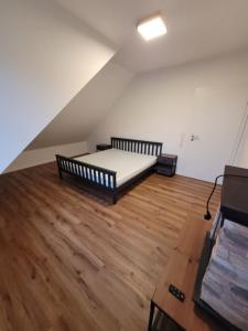 a room with a bed and a wooden floor at Life Zone 11 in Molbergen