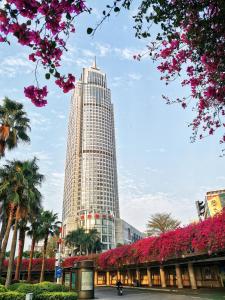 a tall building with pink flowers in front of it at Swissotel Foshan, Guangdong in Foshan