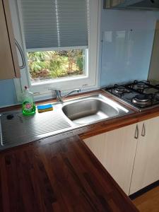 a kitchen with a sink and a window at mobilhome 5 couchages in Nages