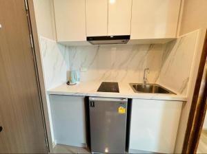 a small kitchen with a sink and a refrigerator at MAHIDOL CONDO in Chiang Mai